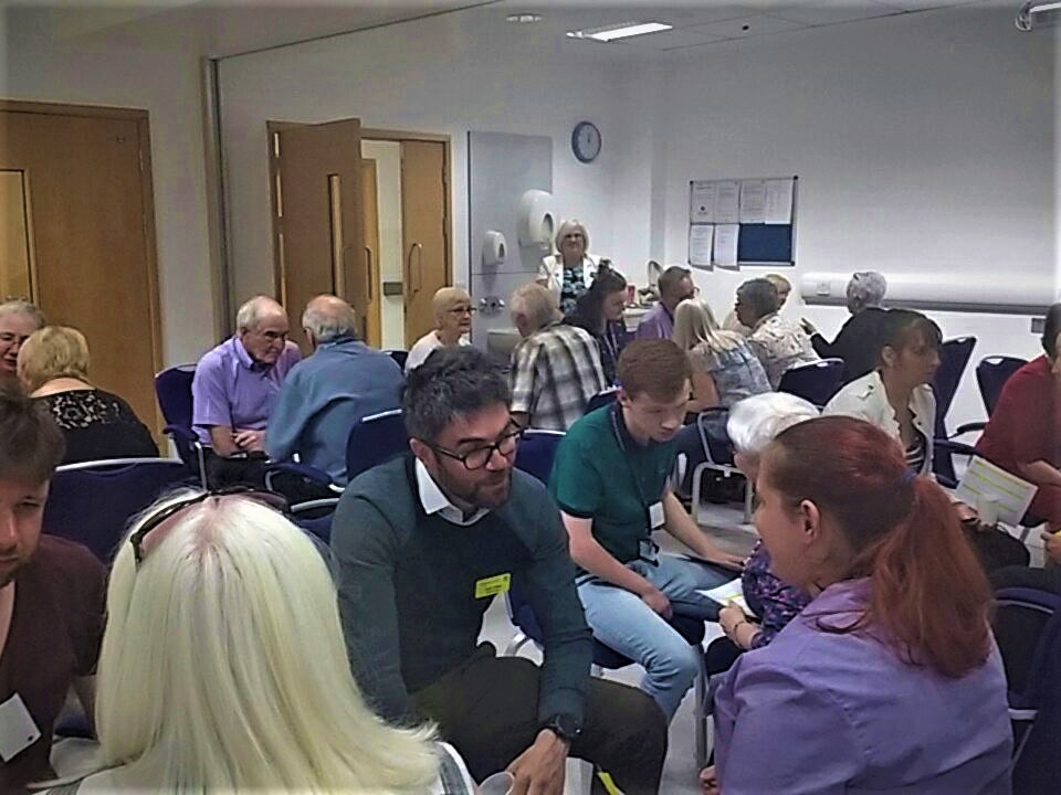 Pairs of people sitting in chairs, talking to each other